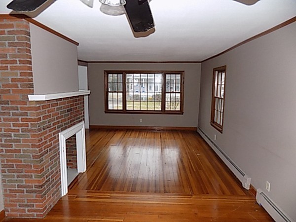 56 Fairview Avenue Chicopee, MA 01013 - Photo 11 of 22 a view of an empty room with wooden floor and windows