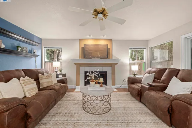 a living room with furniture a fireplace and a flat screen tv