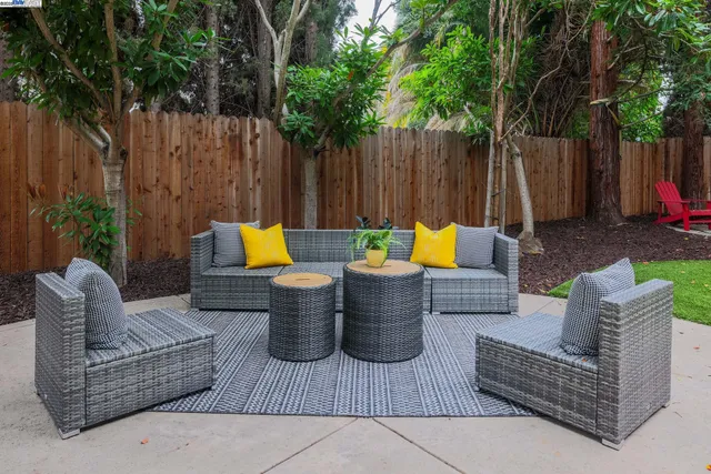 a view of outdoor sitting area with furniture and wooden fence