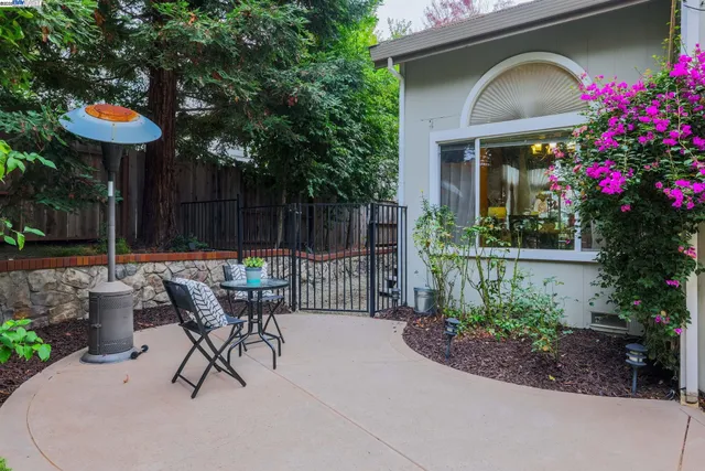 a view of a chair and table in backyard of the house