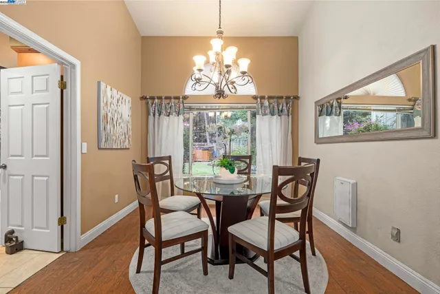 a dining room with furniture a chandelier and wooden floor