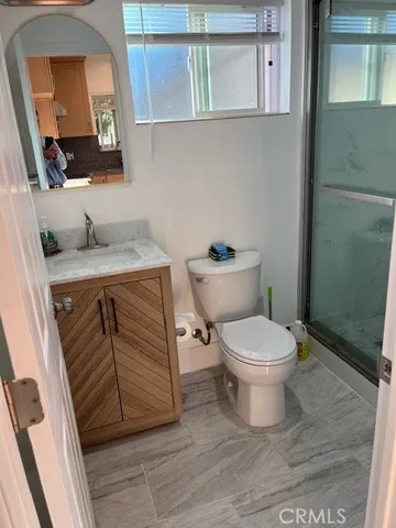 a bathroom with a toilet a sink a vanity and mirror