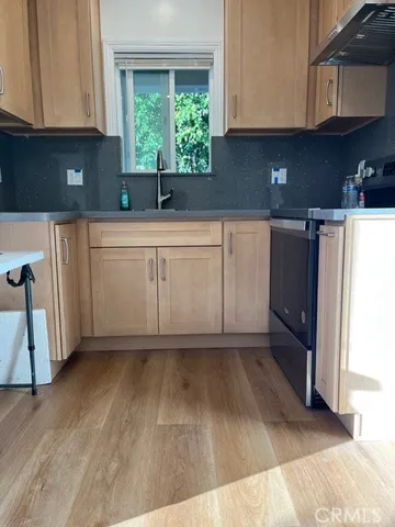 a kitchen with a sink a window and cabinets