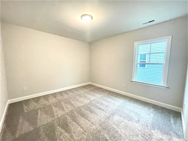 an empty room with closet and windows