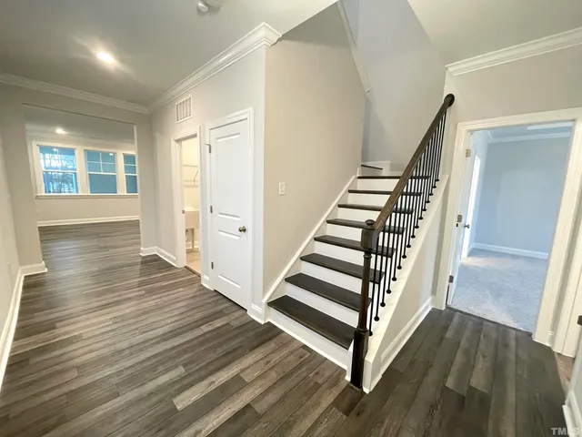 a view of a hallway with wooden floor and stairs