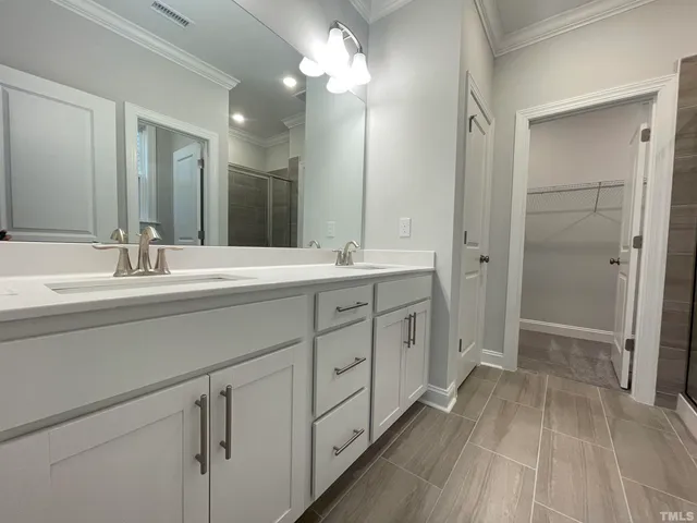 a spacious bathroom with a double vanity sink mirror and shower