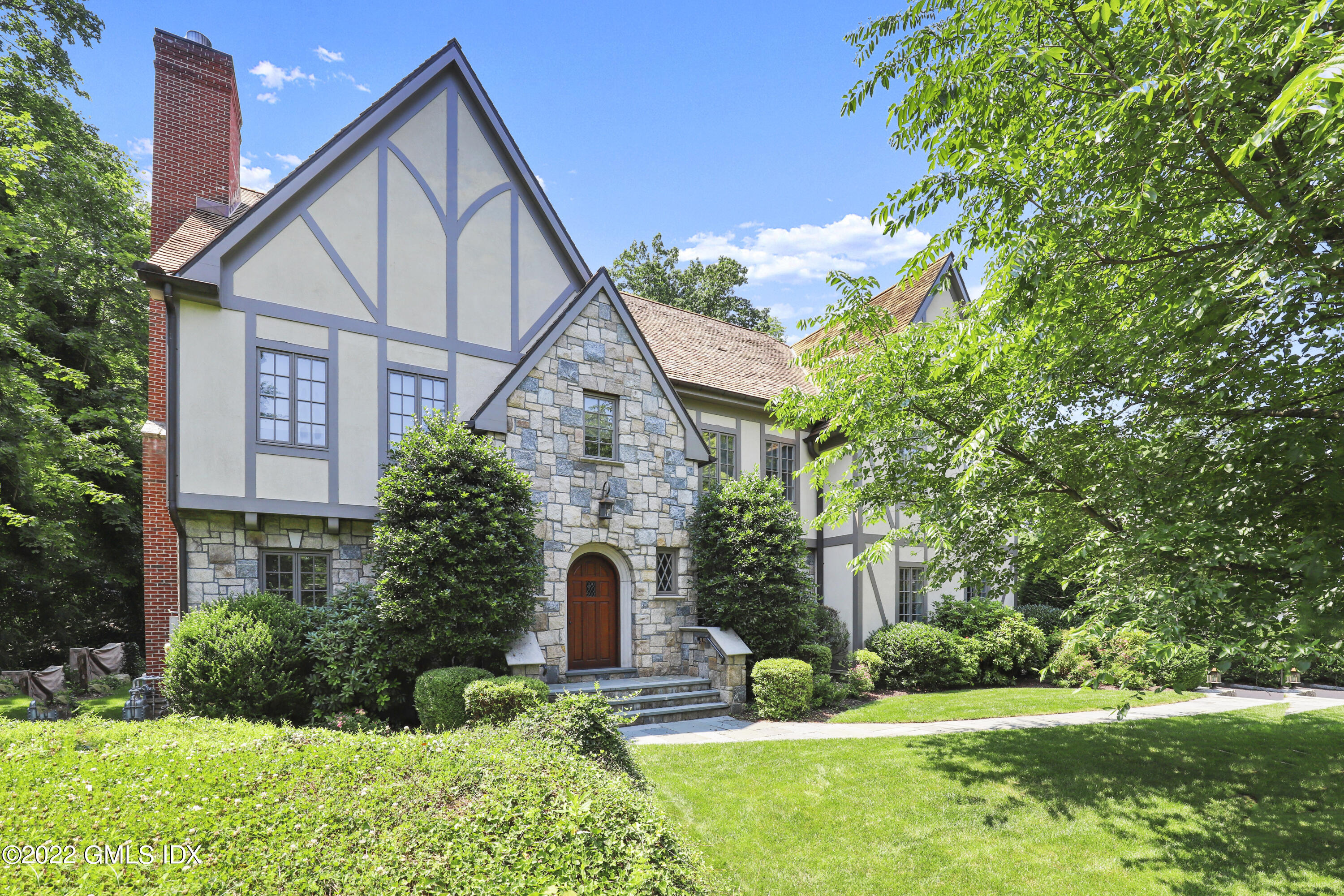 a front view of house with a yard and green space