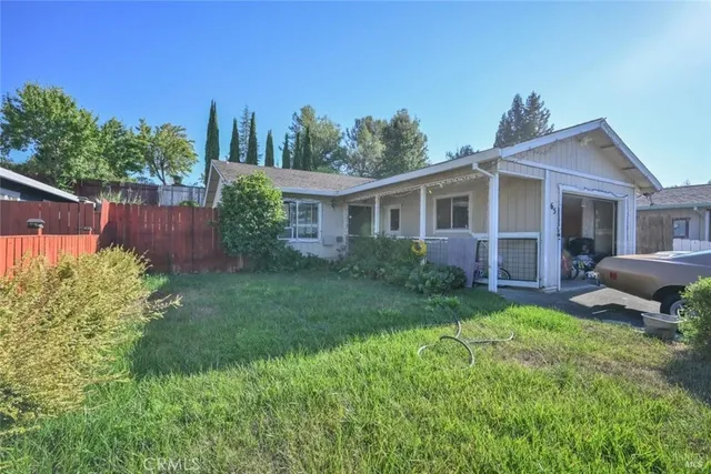 a view of a house with a yard and potted plants