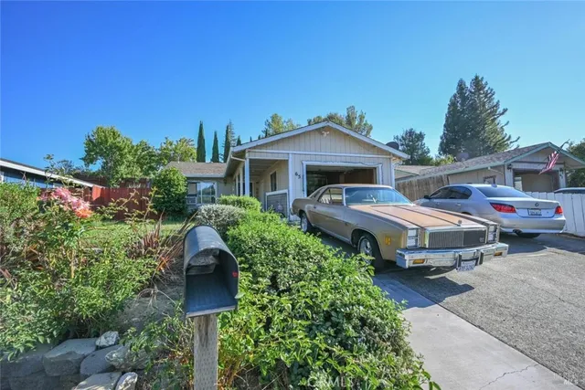 a front view of a house with a garden and trees