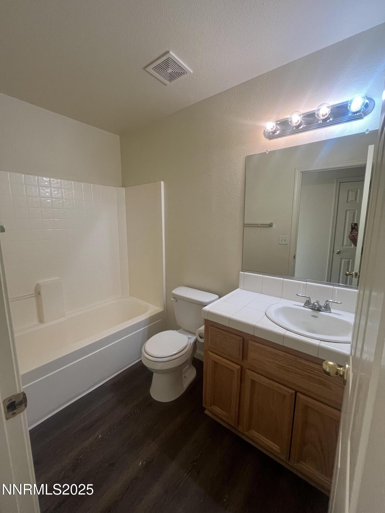 357 Emigrant Way Fernley, NV 89408 - Photo 5 of 7 a bathroom with a sink a toilet a mirror and bathtub