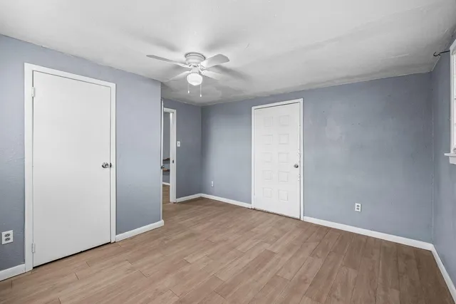 a view of an empty room with wooden floor