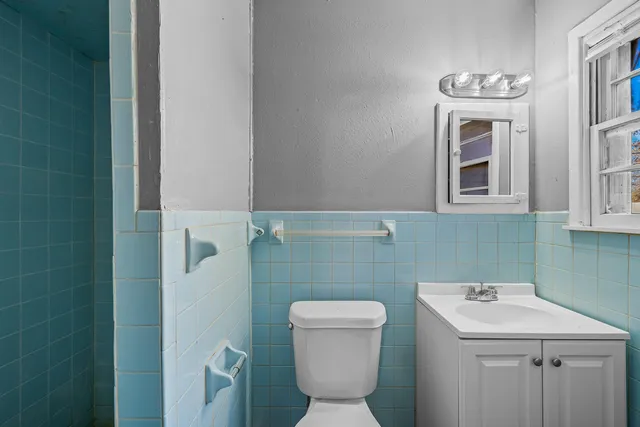 a bathroom with a toilet sink and mirror