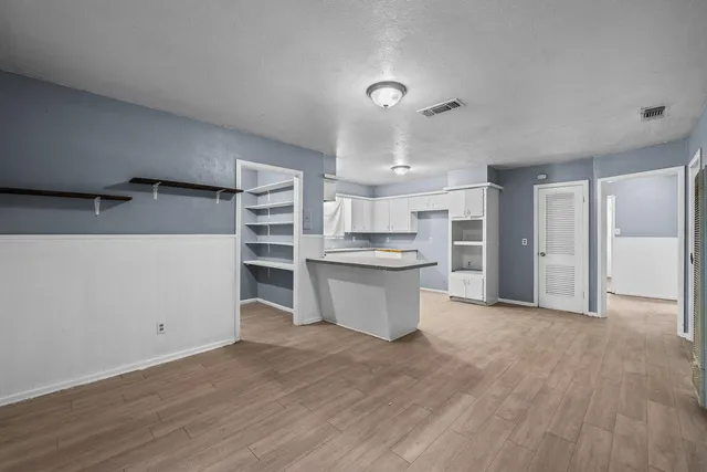 a view of kitchen with wooden floor and electronic appliances