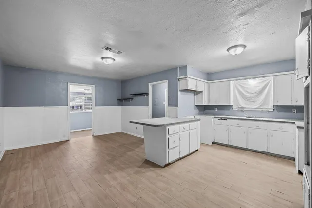 a kitchen with granite countertop white cabinets and white appliances