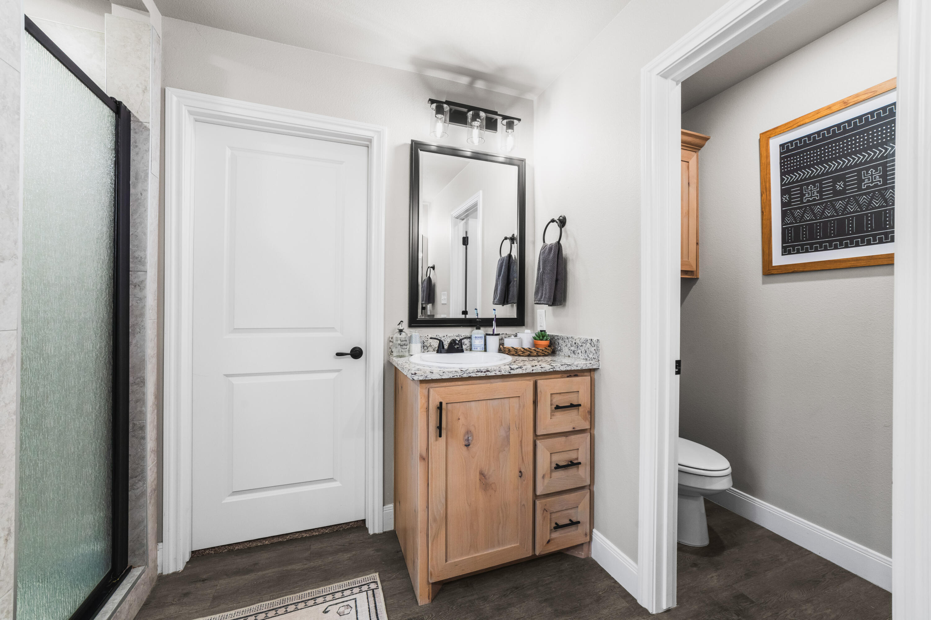 203 Cowboy Lane Wolfforth, TX 79382 - Photo 12 of 21 a bathroom with a toilet a sink and a mirror
