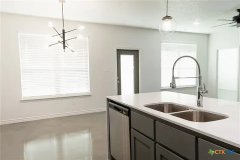 a kitchen with a sink and chandelier