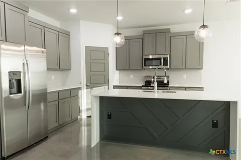 a kitchen with kitchen island a sink stainless steel appliances and cabinets