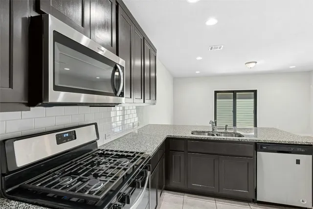 a kitchen with stainless steel appliances granite countertop a refrigerator and a sink