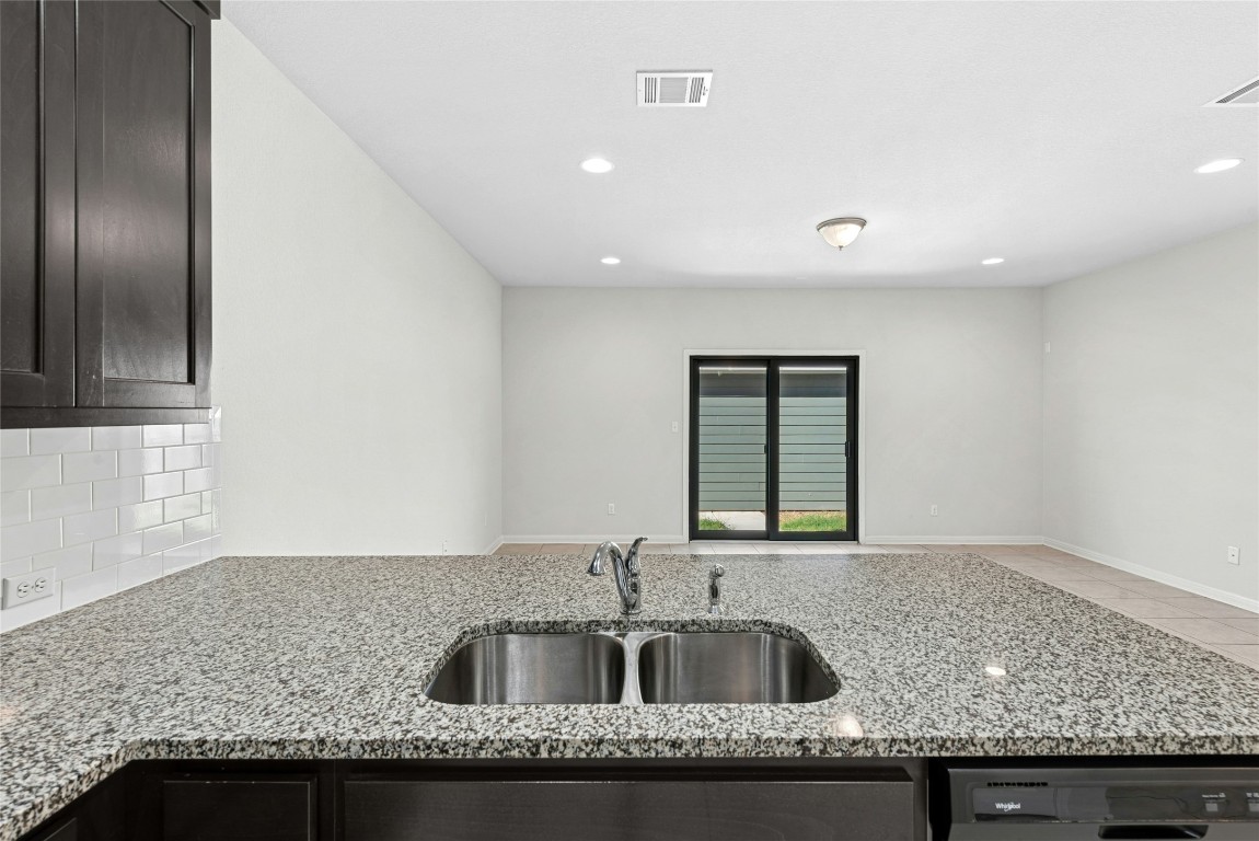 1709 Arendale Drive Leander, TX 78641 - Photo 36 of 36 a kitchen with granite countertop a sink and a wooden floor