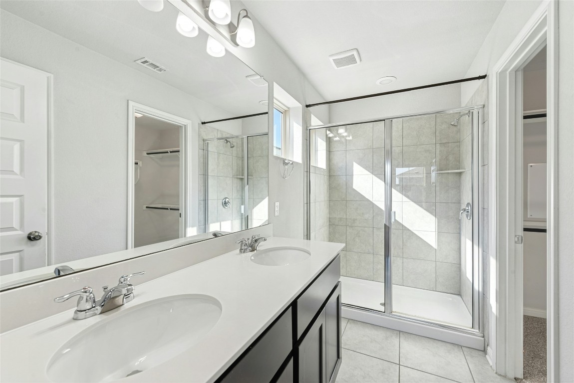 1709 Arendale Drive Leander, TX 78641 - Photo 17 of 36 a bathroom with a shower sink vanity and mirror
