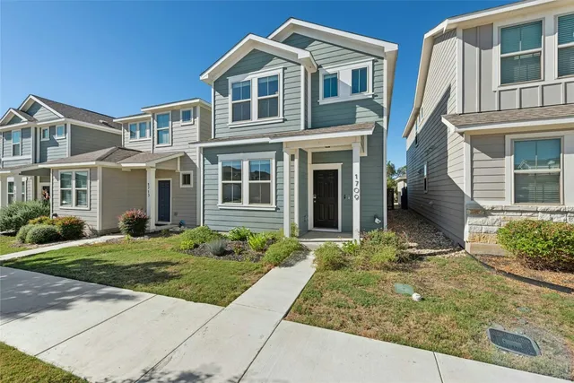 a front view of a house with garden and plants