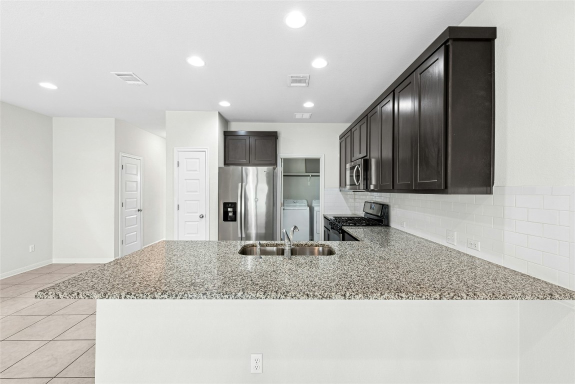 1709 Arendale Drive Leander, TX 78641 - Photo 6 of 36 a bathroom with a granite countertop sink and a mirror