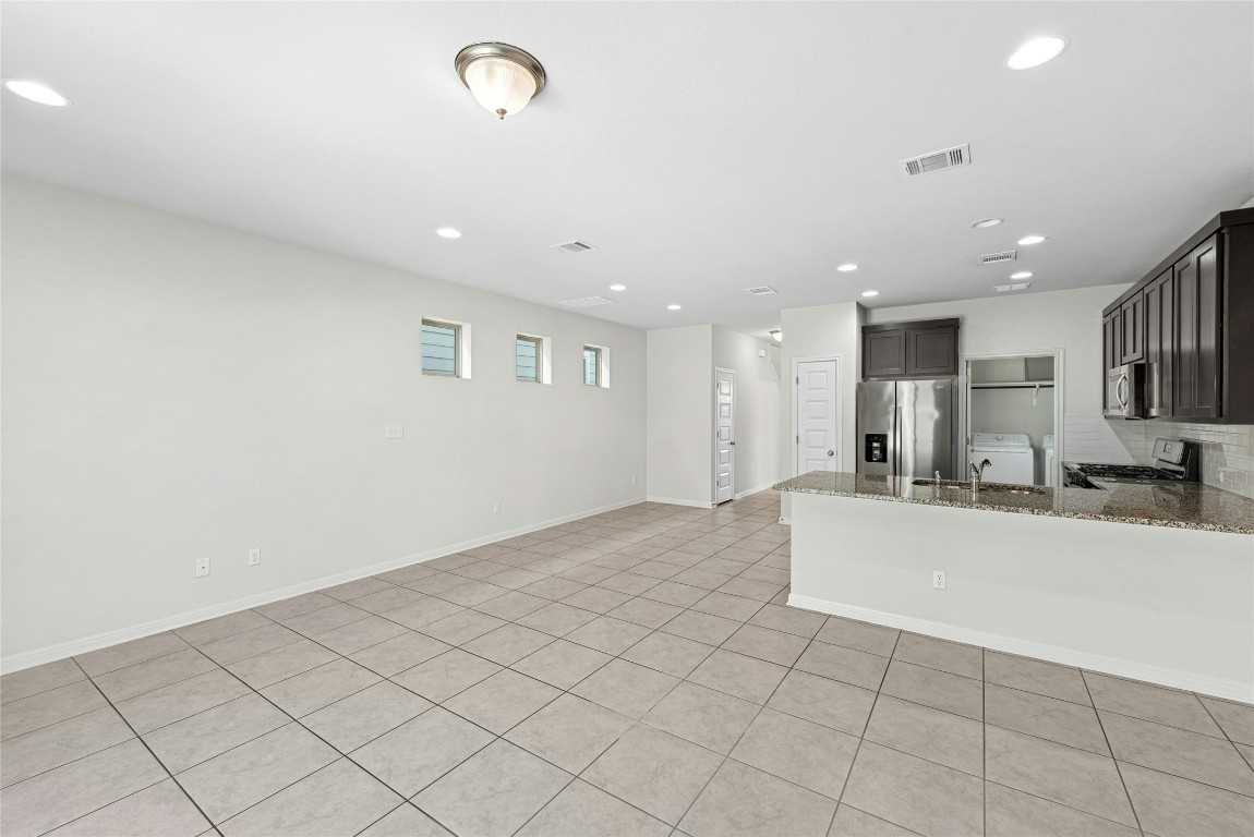 1709 Arendale Drive Leander, TX 78641 - Photo 7 of 36 a large white kitchen with a sink and a stove top oven