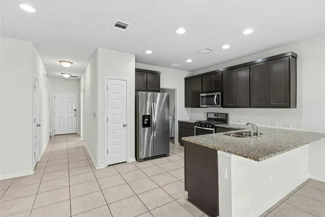 a large white kitchen with a sink and a stove top oven