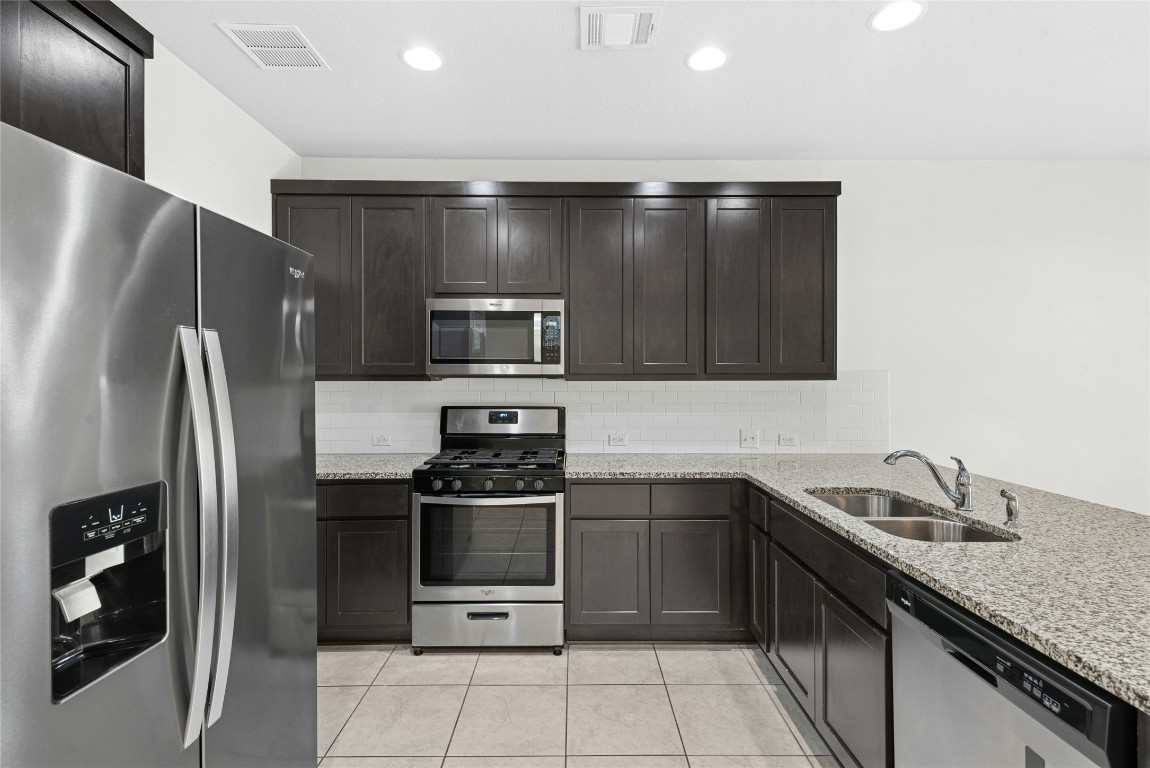 1709 Arendale Drive Leander, TX 78641 - Photo 9 of 36 a kitchen with stainless steel appliances granite countertop a refrigerator and a sink