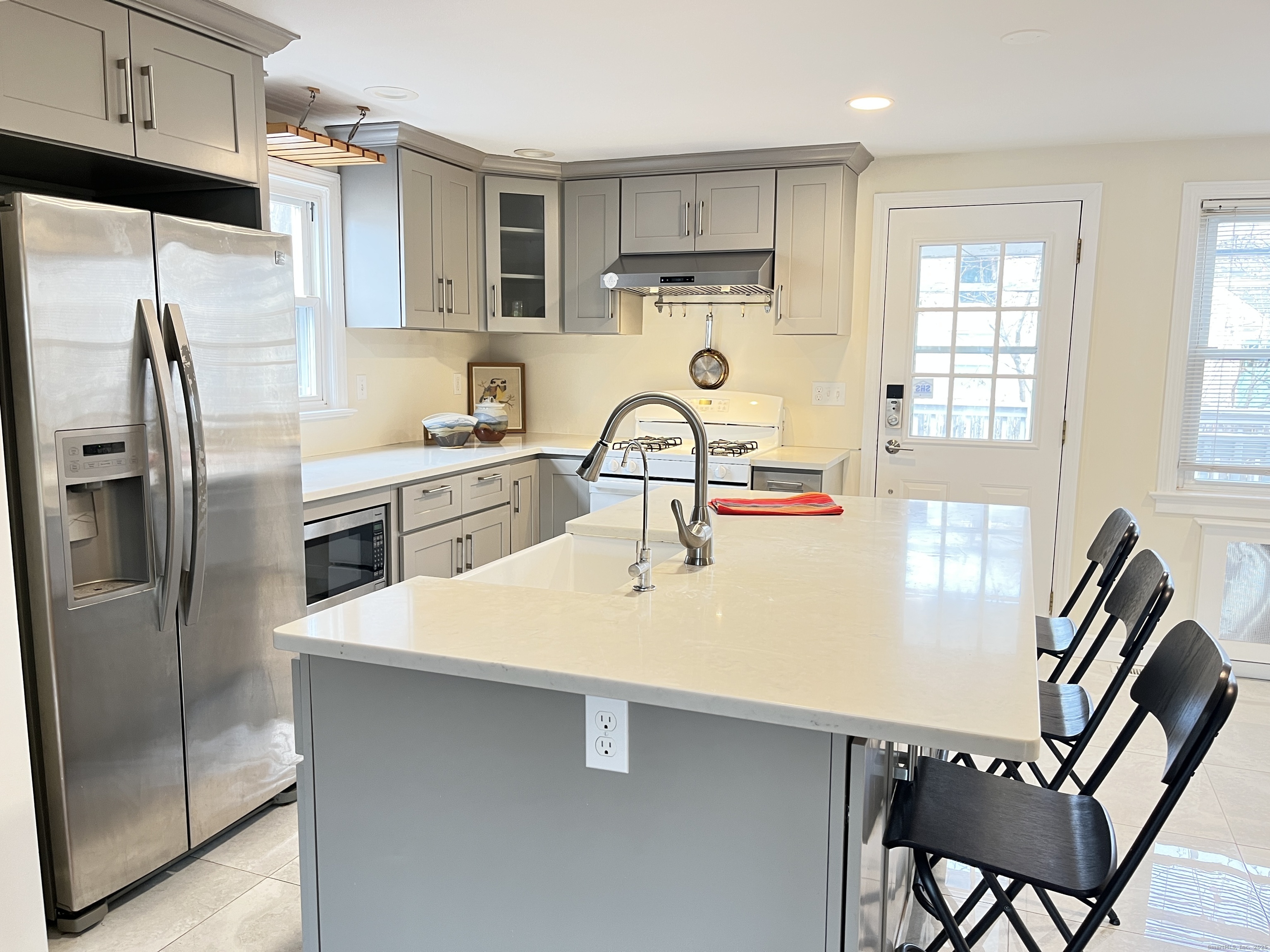 41 Baxter Drive Norwalk, CT 06854 - Photo 2 of 15 a kitchen with stainless steel appliances a sink a stove a refrigerator with white cabinets and wooden floor