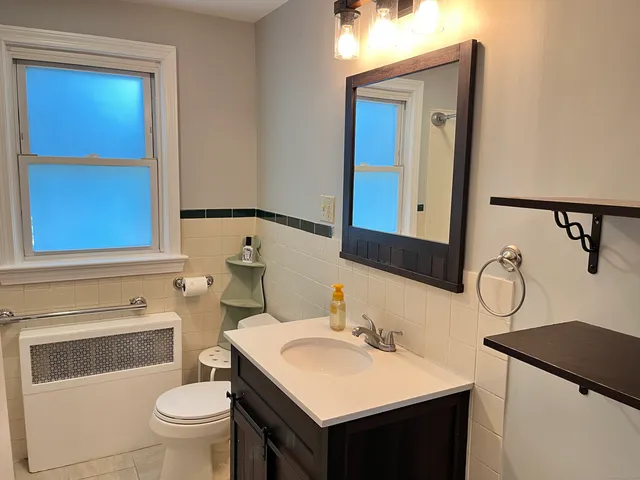 a bathroom with a sink vanity mirror and toilet
