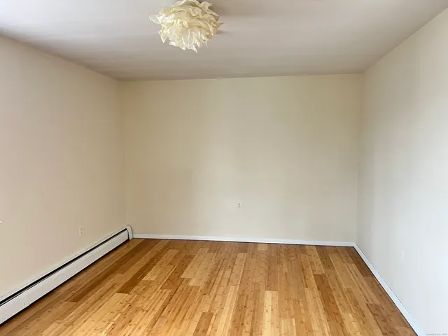 a view of a room with wooden floor and a window