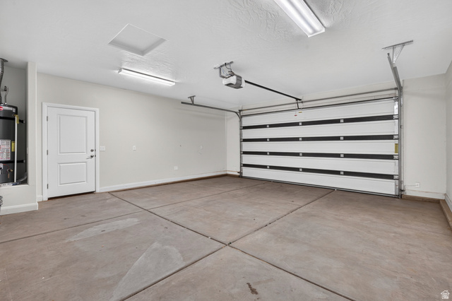 11 East 640 South Ivins, UT 84738 - Photo 39 of 44 Attached garage featuring a white paneled door, concrete flooring, and ceiling-mounted lighting