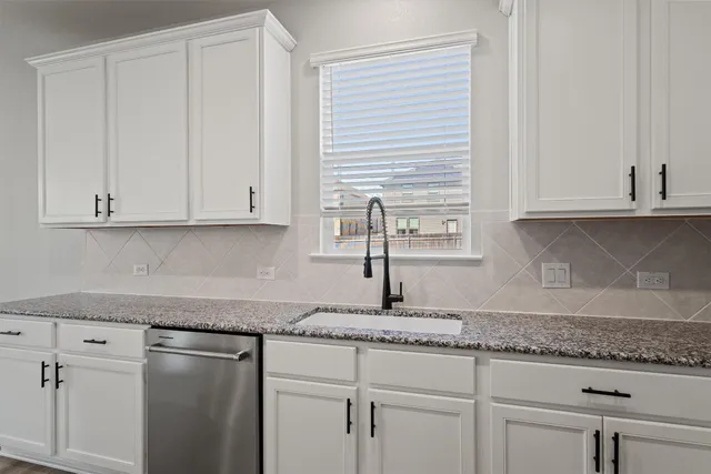 a kitchen with granite countertop white cabinets and white appliances