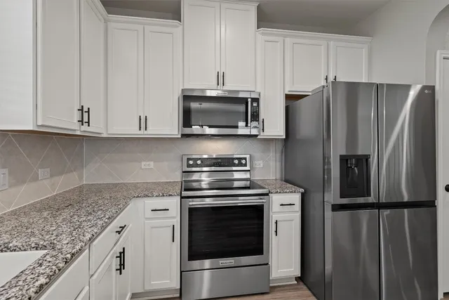 a kitchen with appliances cabinets and a counter top space
