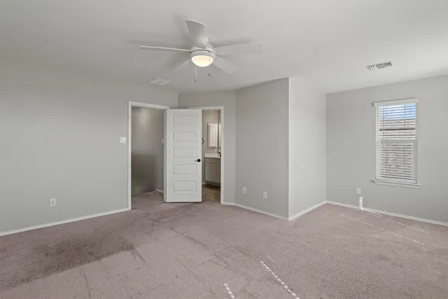 a view of an empty room with a ceiling fan