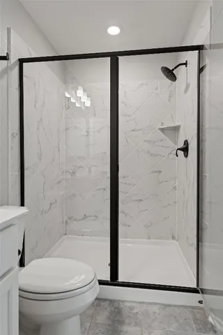 a bathroom with a toilet a sink a mirror and shower