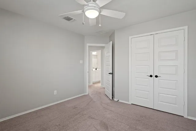 an empty room with a window and a fan