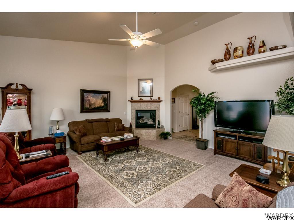 4280 East Cane Ranch Road Kingman, AZ 86401 - Photo 9 of 35 a living room with furniture a flat screen tv and a fireplace