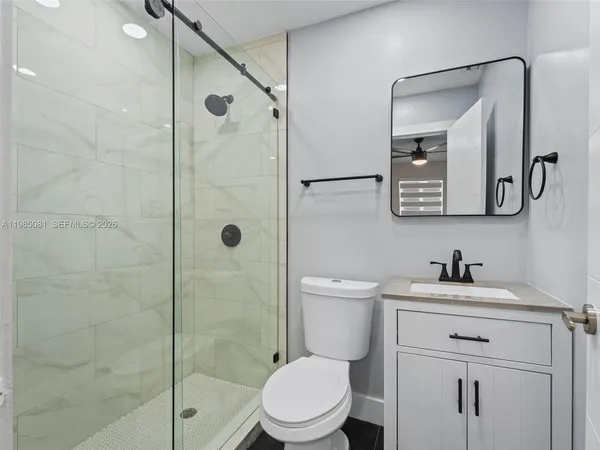 a bathroom with a sink a toilet and shower