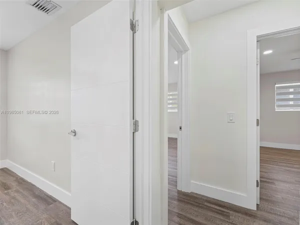 a view of a hallway with wooden floor