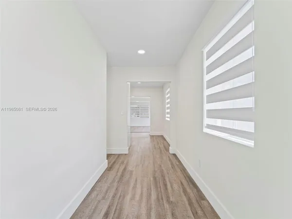 a view of a room with wooden floor and window