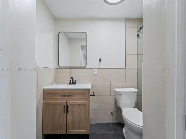 a bathroom with a toilet a sink and mirror