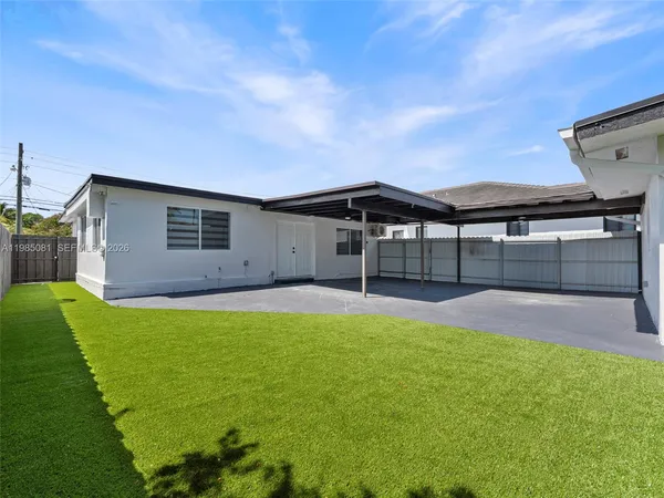 a view of a house with a backyard and a table and chairs