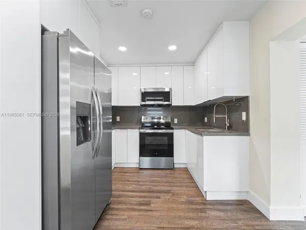 a kitchen with granite countertop a refrigerator and a stove