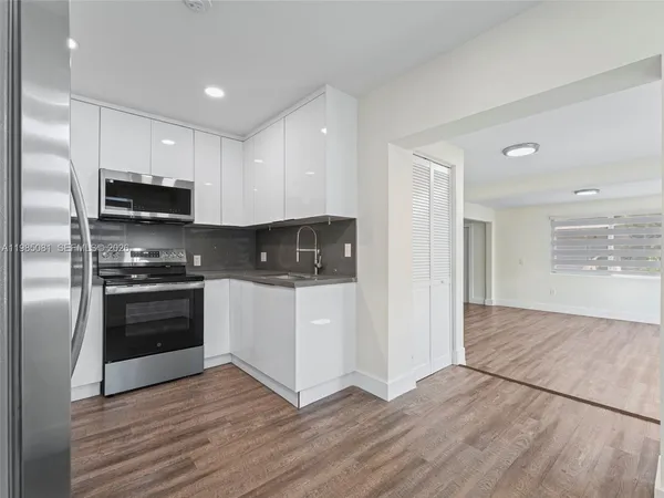 a kitchen with granite countertop a refrigerator and a stove top oven