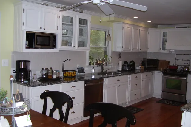 a kitchen with kitchen island granite countertop a refrigerator and a sink