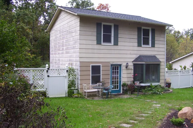 a view of a house with a yard and a large tree