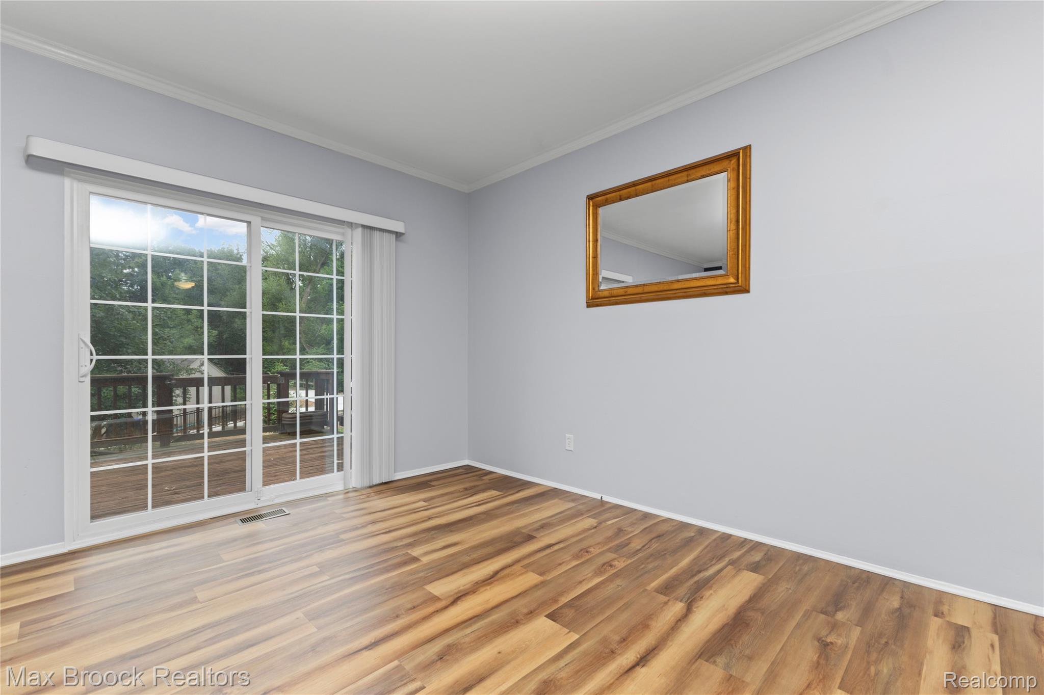 1157 Pine Ridge Court Rochester, MI 48306 - Photo 17 of 55 Bright corner room featuring gleaming wood-finish flooring, floor-to-ceiling glass doors with transom windows, and abundant natural light