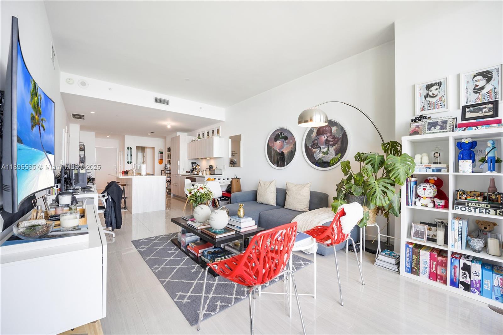 480 Northeast 31st Street, Unit 1602 Miami, FL 33137 - Photo 4 of 12 a living room with furniture and a book shelf